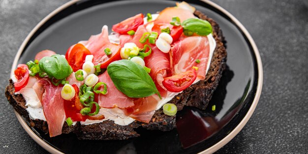 Bruschetta szynka pomidory zielone danie świeże pyszne jedzenie gurmańskie tło na stole wiejskie jedzenie widok z góry przestrzeń kopiowania