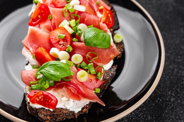 Bruschetta szynka pomidory zielone danie świeże pyszne jedzenie gurmańskie tło na stole wiejskie jedzenie widok z góry przestrzeń kopiowania