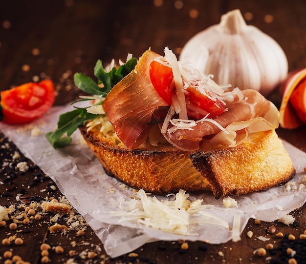 Bruschetta z pomidorami prosciutto, rukolą i parmezanem