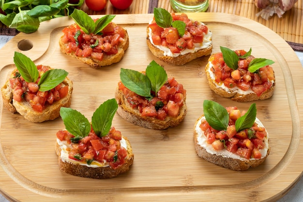 Bruschetta z pomidorową ricottą i bazylią na drewnianej desce