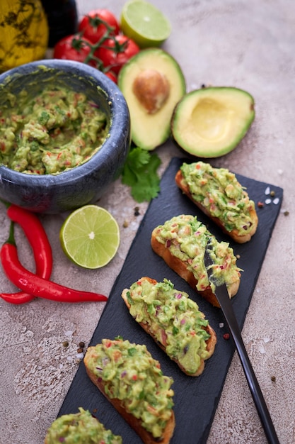 Bruschetta ze świeżo zrobionym guacamole na szarym betonowym tle