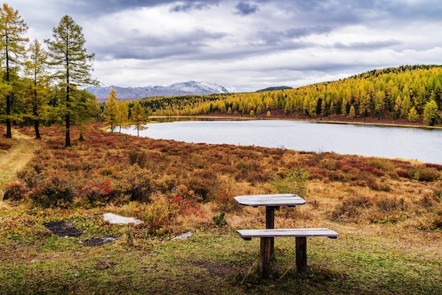 brzeg jeziora Kidelu i ośnieżone szczyty grzbietu Kurai Jesienny krajobraz górski Ałtaj Rosja
