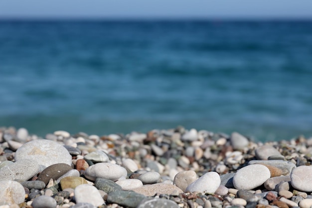 Brzeg kamyków z morzem i plażą w tle