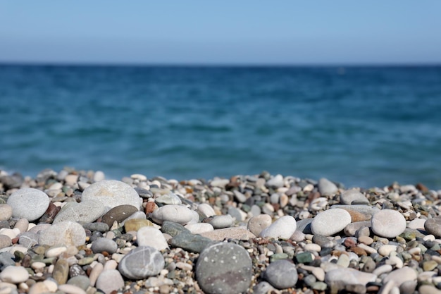 Brzeg kamyków z morzem i plażą w tle