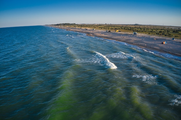 Brzeg morza w wieczornym słońcu. Plaża kempingowa.