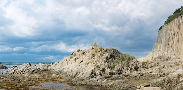 Brzeg oceanu ze skałami kolumnowego bazaltowego przylądka Stolbchaty na wyspie Kunashir