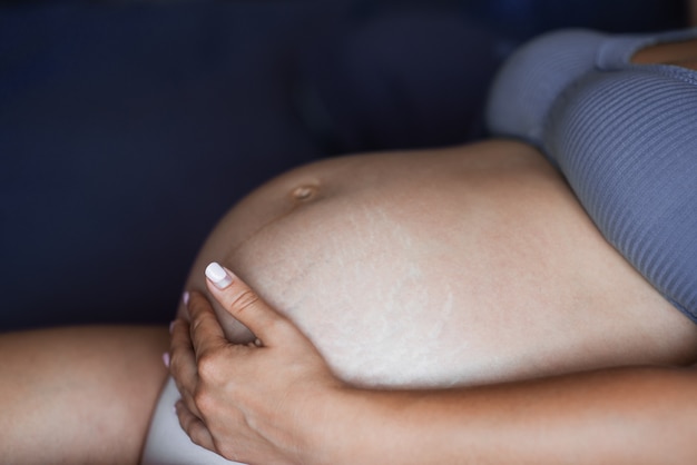 Brzuch Kobiety W Ciąży Jest Zbliżenie. Naturalna Tekstura Skóry. Skóra Uszkodzona Z Rozstępami, Bliznami, Paskami