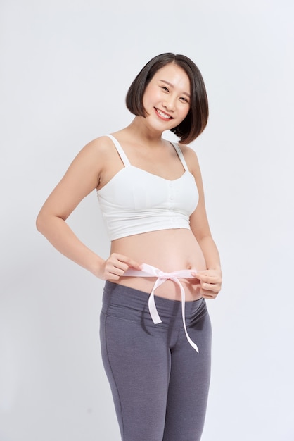 Brzuch w ciąży z różową wstążką - macierzyństwo