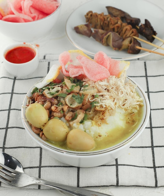 Bubur ayam lub indonezyjska owsianka ryżowa podawana z rozdrobnionym kurczakiem, ciastem, chili i wysokiej jakości jajkami.select