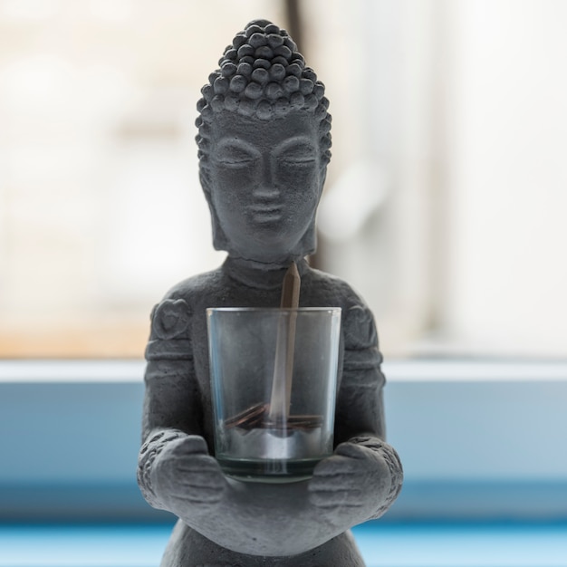 Zdjęcie buddha cement z szkłem z monetami i ołówkiem