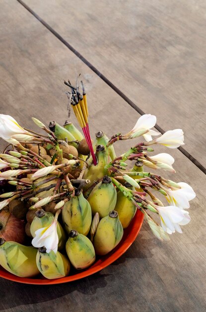 buddyjska miska z kadzidłem, owocami i kwiatami