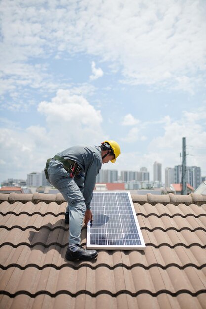 Budowniczy instalujący panel słoneczny na dachu klienta