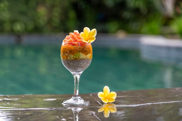 Budyń z nasion chia z papai marakui mango i awokado w szklance na śniadanie na tle basenu zbliżenie wody Pojęcie zdrowego odżywiania superfood