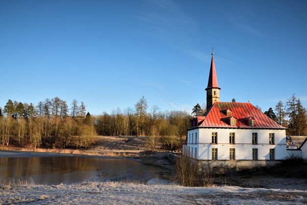 Budynek nad rzeką na tle jasnego niebieskiego nieba