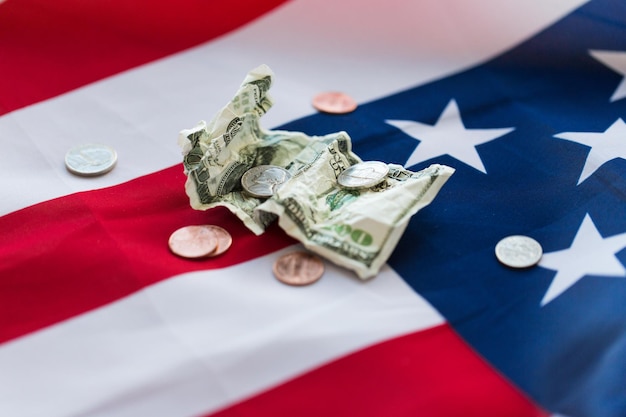 budżet, pieniądze, finanse, kryzys finansowy i koncepcja nacjonalizmu - zbliżenie amerykańskiej flagi i monet centowych ze zmiętym banknotem dolarowym