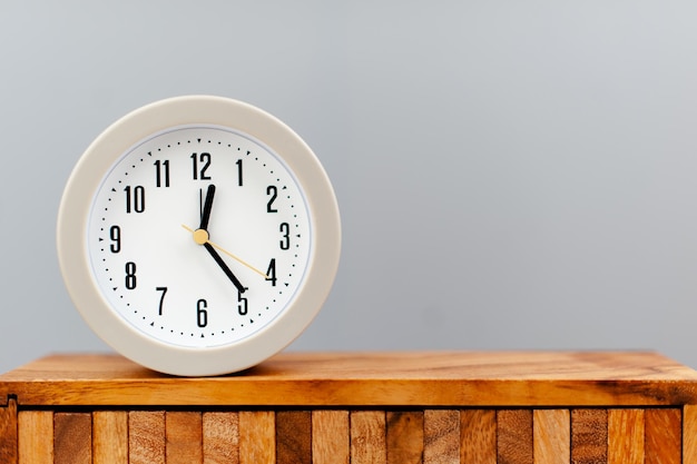 Budzik umieszczony na drewnianej desce pracujący z koncepcją czasu wartości czasu