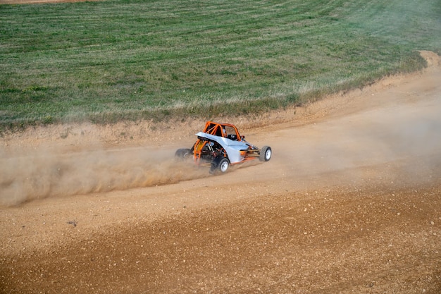 Zdjęcie buggy na torze autocrossowym ślizgają się pod oponami kurzu i brudu