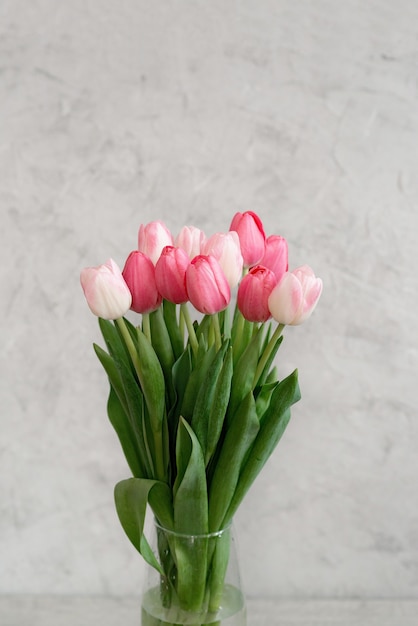 Bukiet delikatnych różowych tulipanów w wazonie na wakacje. Dzień Matki, urodziny, walentynki. kartka z życzeniami. miękkie selektywne ustawianie ostrości.