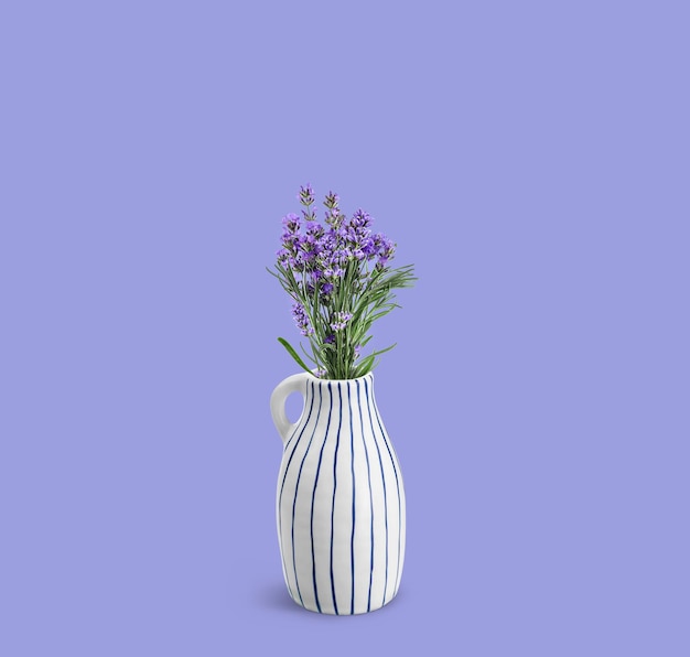 Bukiet kwiatów lawendy w ceramicznym wazonie na fioletowym lawendowym tle