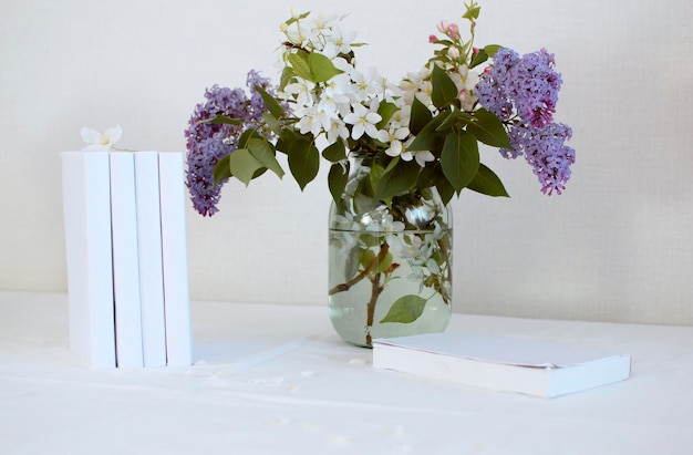 Bukiet kwiatów w wazonie i książki na stole w domu Koncepcja czytania relaksującego sezonu letniego