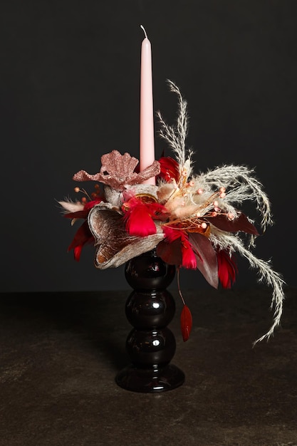 Zdjęcie bukiet kwiatowy z różową świecą do dekoracji świąt za pomocą suszonych kwiatów