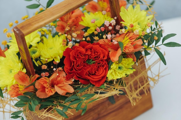 Bukiet piwonii chryzantemowej, róży i alstremerii w drewnianym pudełku na szarym tle Dostępny w kolorze czerwonym, pomarańczowym i żółtymzbliżenie