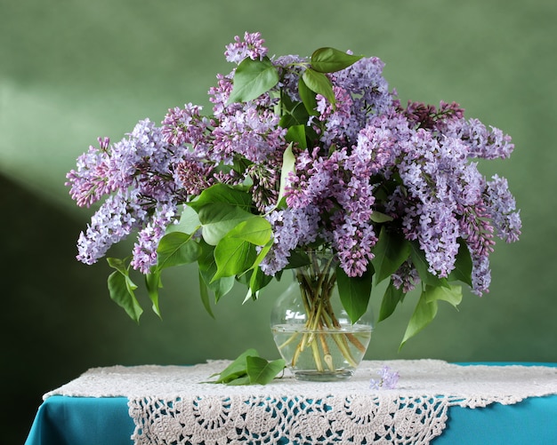 Bukiet purpurowy bez w szklanej wazie. martwa natura z kwiatami.