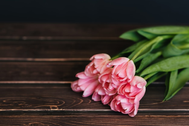 Bukiet różowi tulipany na drewnianym stole