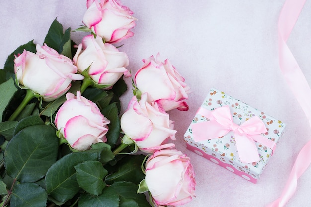 bukiet różowych róż i pudełko z prezentem