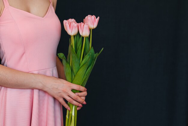 Bukiet różowych tulipanów w rękach kobiet