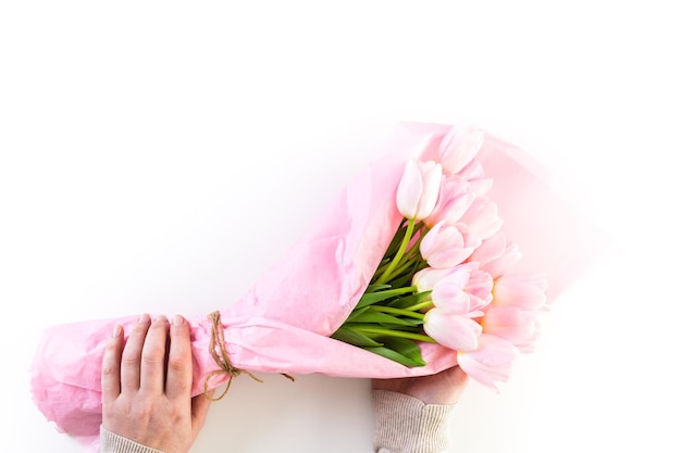 Bukiet różowych tulipanów zawinięty w różowy papier.