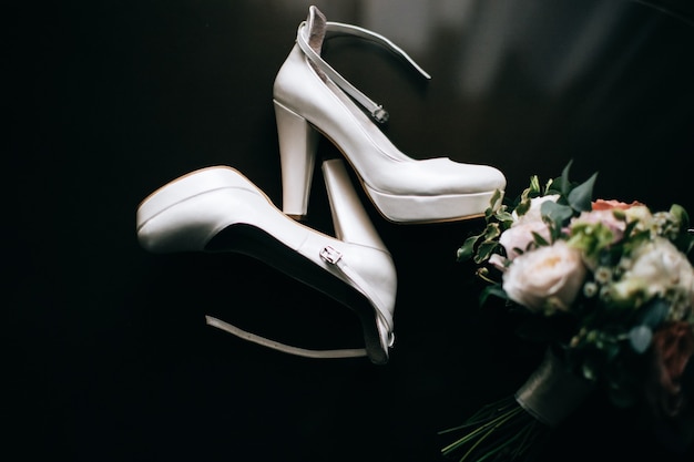 Bukiet ślubny z butami w pokoju narzeczonych