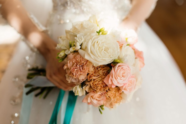 Bukiet ślubny z kwiatów w rękach panny młodej