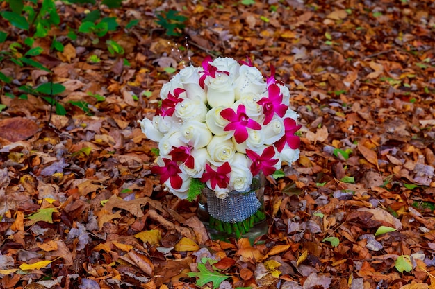 Bukiet ślubny z róż na drewnianych deskach Bukiet ślubny z białych róż na tle liści