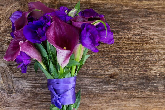 Bukiet świeżych kwiatów calla lilly i eustoma na drewnianym stole