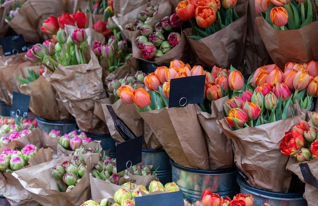Bukiety kwiatów ze stoiska z tulipanami w metalowych wiaderkach