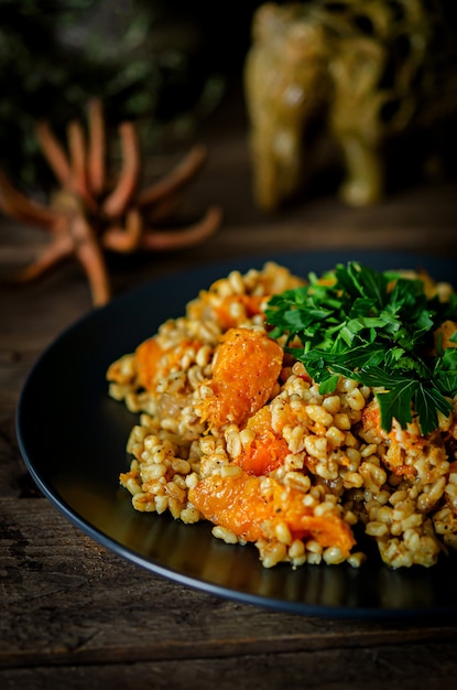 Bulgur Z Dynią Na Drewnianym Stole. Przepisy Wegetariańskie Z Kuchni Indyjskiej.