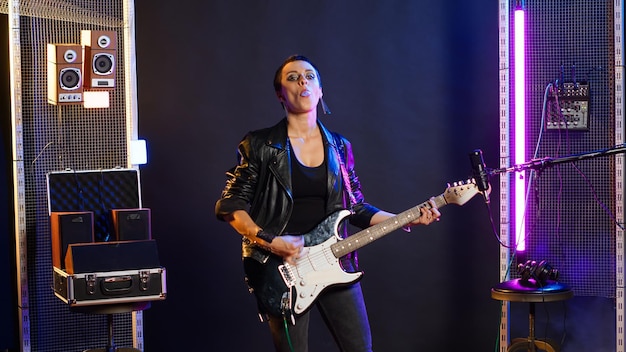 Buntliwa, lekkomyślna kobieta grająca na gitarze i robiąca bąbelki z gumy do żucia.