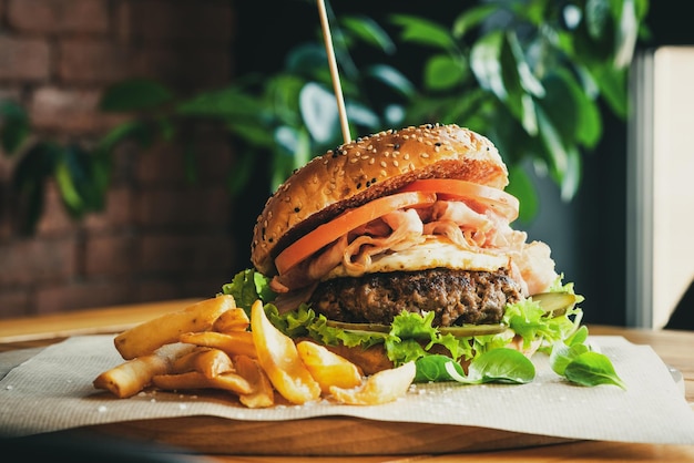 Burger Jajko Wołowe i Bekon Serwowane w Restauracji Amerykańskie Jedzenie Smaczny Smakosz na Drewnianym Stole