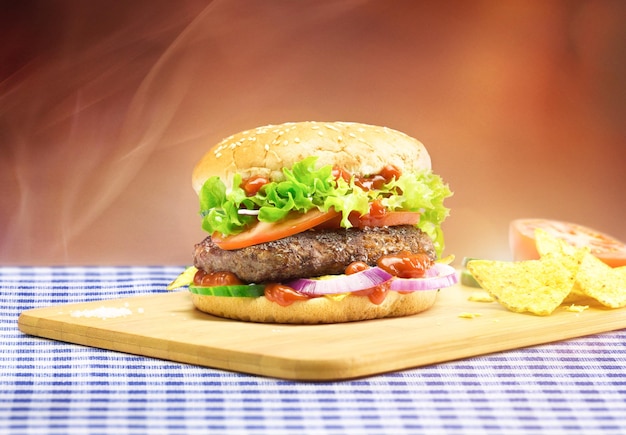Burger na desce do cięcia przy stole w restauracji