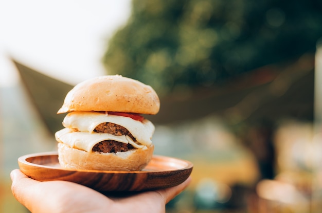 Zdjęcie burger podczas biwakowania w dzikim miejscu obozowym, obozowe gotowanie nad brzegiem jeziora.