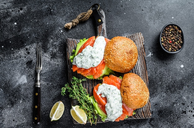 Burger rybny z solonym łososiem, awokado, sosem musztardowym, ogórkiem i sałatką lodową