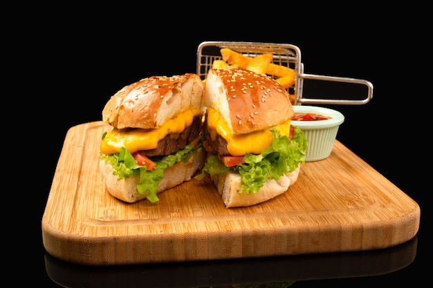 Zdjęcie burger serowy z pomidorem i sałatą oraz frytki z keczupem