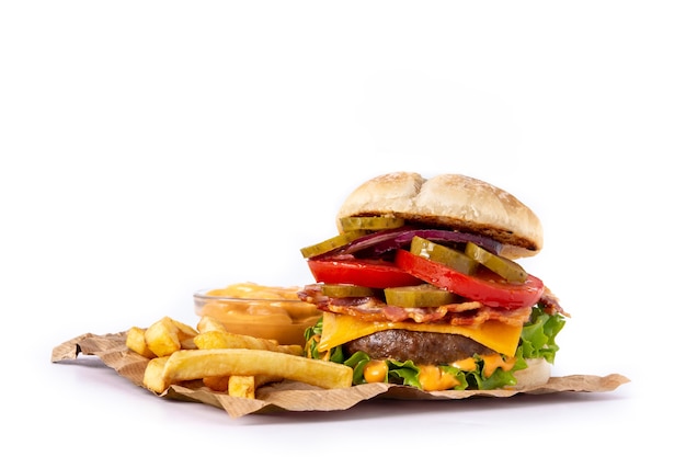 Burger wołowy z serem, boczkiem i frytkami na białym tle