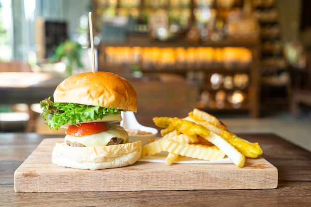 burger wołowy z serem i chipsami ziemniaczanymi na drewnianej tacy