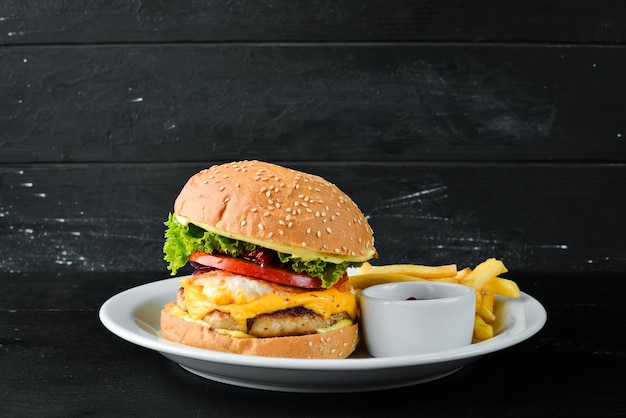 Burger z cielęciną, serem i warzywami. Fast food. Na drewnianym tle. Widok z góry. Wolne miejsce na Twój tekst.