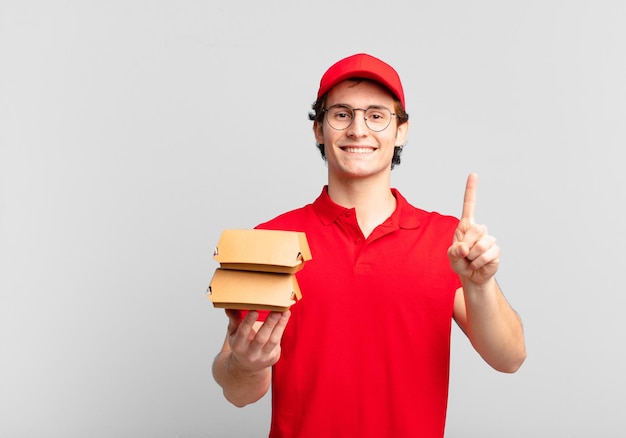 Burgery Dostarczają Chłopcu Uśmiechniętego I Przyjaznego, Pokazując Numer Jeden Lub Pierwszy Z Ręką Do Przodu, Odliczając