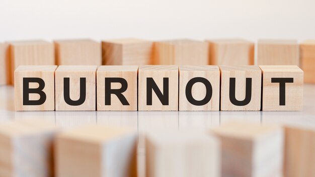 Burnout - drewniane litery na biurku, białe tło, koncepcja biznesowa