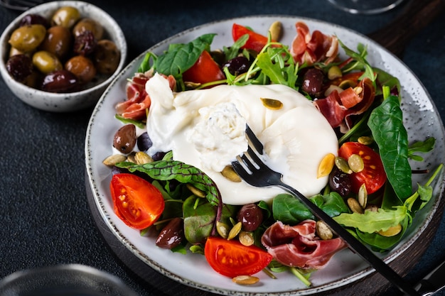 Burrata Włoski świeży ser ze śmietany i mleka bawolego lub krowiego Sałatka Burrata z pomidorami i mieszanką sałat Zdrowa koncepcja odżywiania Sałatka keto dieta