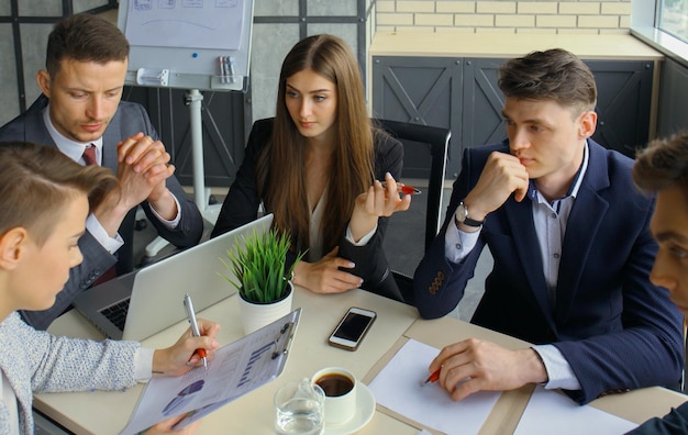 Burza mózgów Grupa ludzi biznesu patrząca razem na laptopa Jedna kobieta biznesu patrząca na kamerę